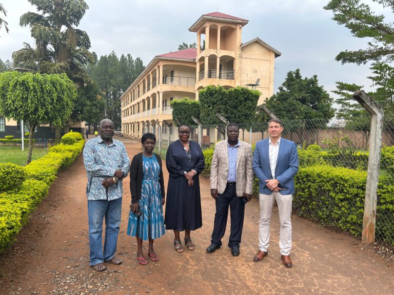 Rainer Jünger mit Vertreterinnen und Vertretern der Gulu School of Nursing vor dem Schulgebäude in Gulu, Uganda